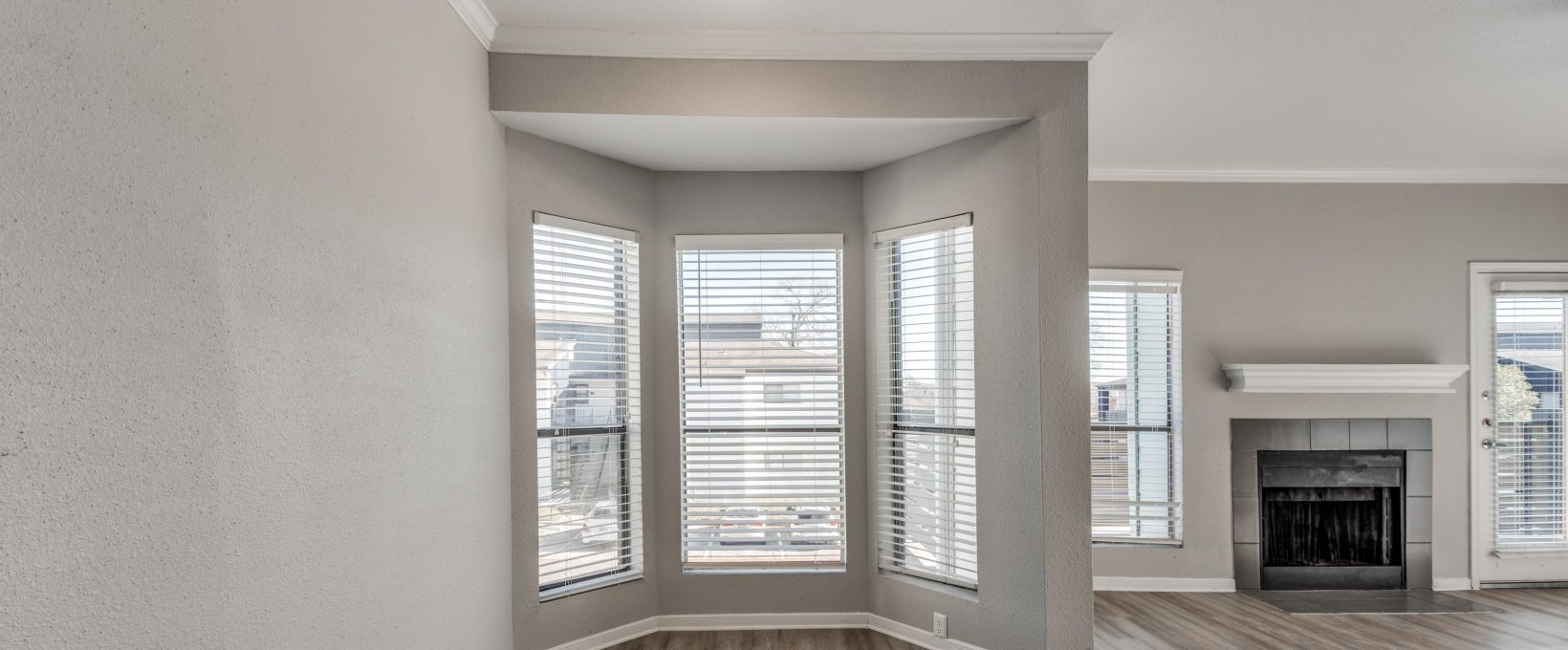 empty living room with hardwood floors and large windows at The Pearce on  Lake